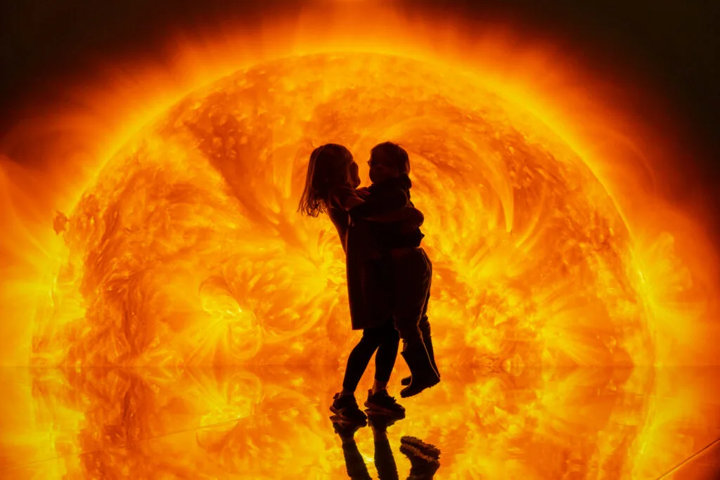 Children silhouetted against a sun backdrop.