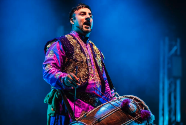 Man with a drum, wearing bright clothing